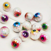 Un ensemble de dix perles à lentilles oculaires en acrylique irisées avec des iris colorés et détaillés, éparpillés sur une s
