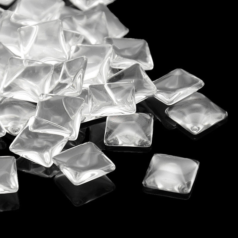 A pile of clear, square decorative refrigerator magnets for custom crafts.