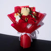 A bouquet of handmade crochet yarn flowers in yellow and red nestled in a red gift paper.