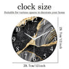 A round black marble textured glass wall clock with gold accents showing the time.