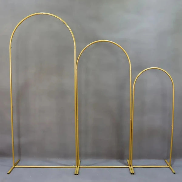 A set of three gold-colored metal arch stands or hoops displayed against a gray background.