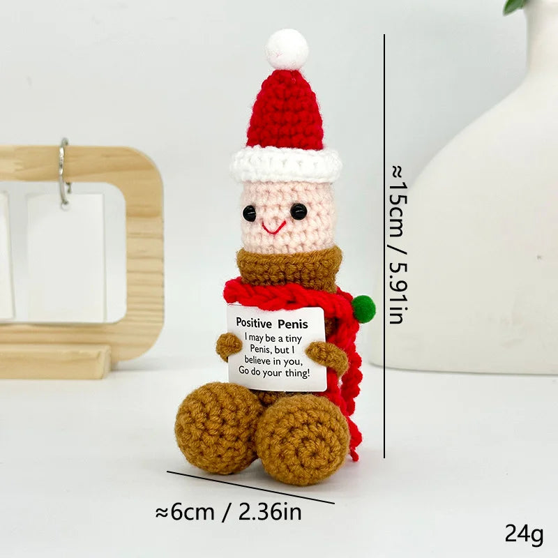 A handmade crochet figurine decoration shaped like a smiling face wearing a red and white knitted hat and a red scarf.