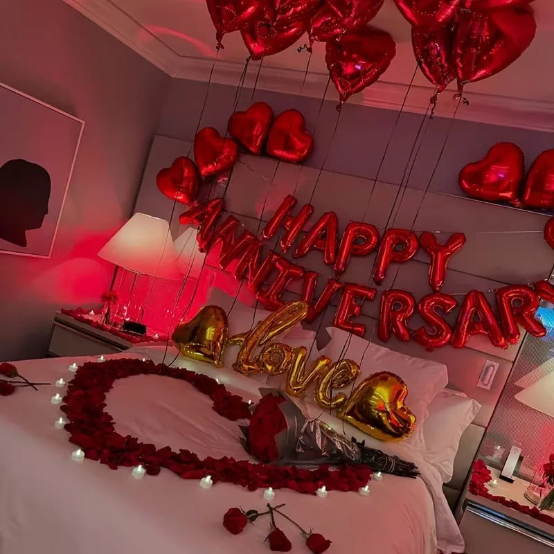 A bed decorated with red and gold heart decor, including hanging hearts and a heart-shaped sign.