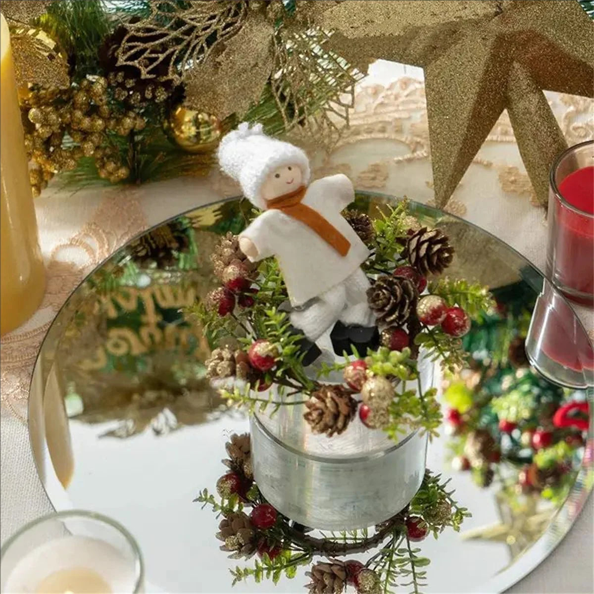 A silver mirror plate features a centerpiece of pinecones, greenery, and a white figure for wedding or party decor.