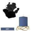 A blue candle in a gold wire holder next to a black dye block and a grey color swatch.