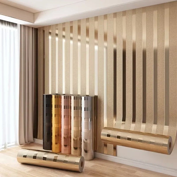 Metallic gold striped peel-and-stick wallpaper covering a wall with vertical stripes and decorative trim.