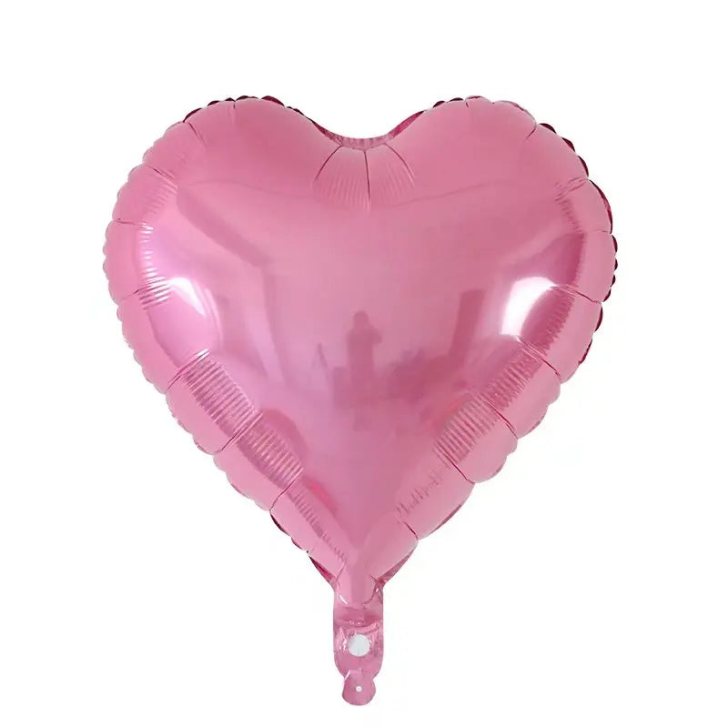 A pink heart-shaped foil balloon used for celebrations.