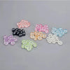 A collection of glow-in-the-dark resin ghost tree elves in various colors including pink, purple, black, and blue.