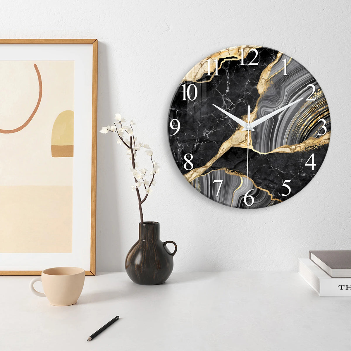 A round wall clock with a black and gold marble pattern on a white background, displayed on a light surface.