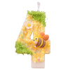 A yellow birthday candle shaped like the number four decorated with green moss and a bee.