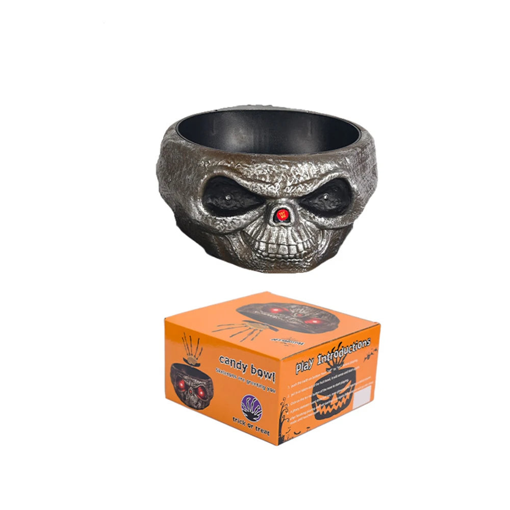 A dark metal bowl shaped like a skull with glowing red eyes, used as a Halloween ghost fruit bowl.