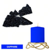 A blue candle in a gold holder next to black sapphire dye blocks.
