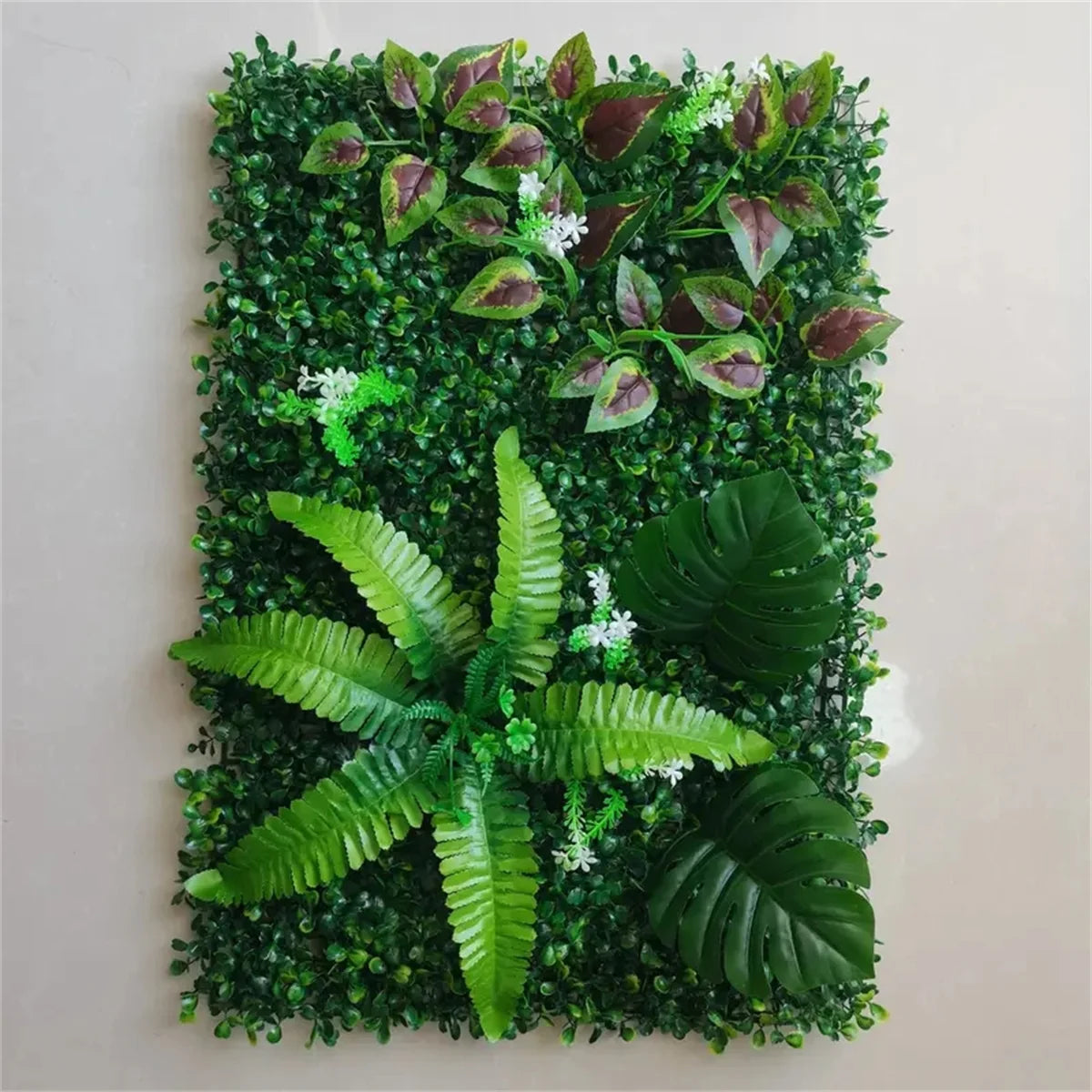 Artificial green plant wall panel featuring realistic 3D foliage and various green leaves