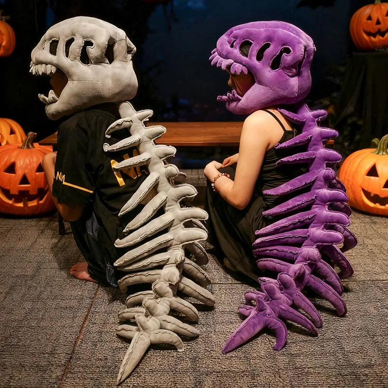 Jouet en peluche représentant un squelette de dinosaure avec un crâne gris et des côtes violettes, exposé sur un fond sombre.