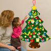 Una mujer y un niño decorando un árbol de Navidad verde con adornos de fieltro coloridos.