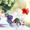 A set of ten gold metal hoop centerpieces with stands featuring floral arrangements and a glass.