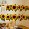 A display of pastoral sunflower wall stickers featuring bright yellow and dark brown flowers on a white wall.