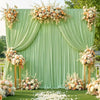 A lush green backdrop decorated with white and peach floral arrangements for a wedding or event.