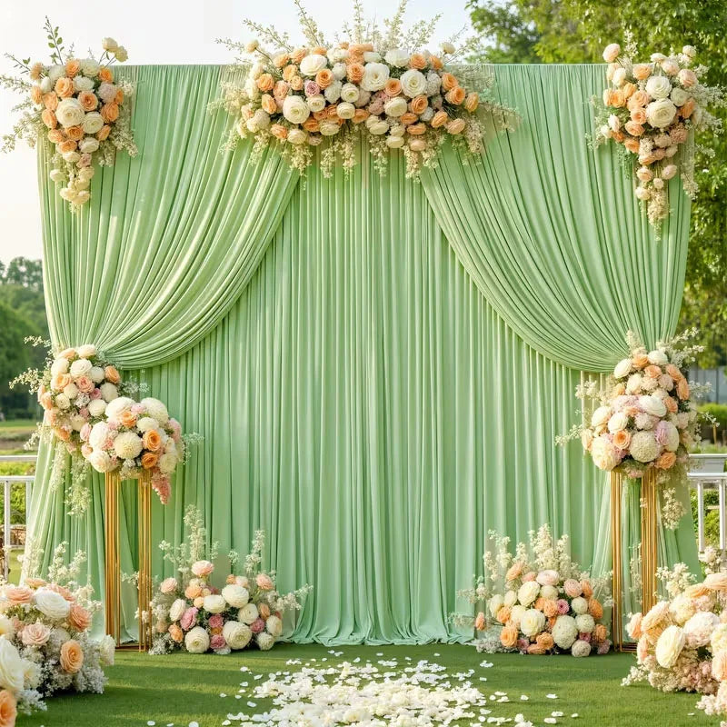 A lush green backdrop decorated with white and peach floral arrangements for a wedding or event.