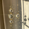 Un diffuseur de soleil en cristal doré avec plusieurs éléments en verre suspendus.