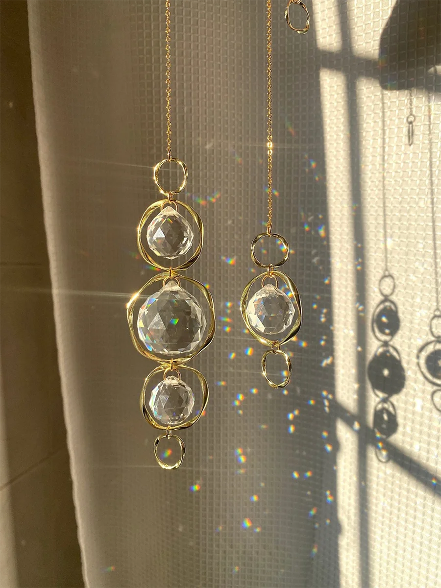 Un diffuseur de soleil en cristal doré avec plusieurs éléments en verre suspendus.