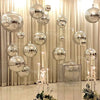 A display of metallic silver foil balloons hanging in front of sheer curtains.