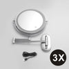 A round, silver-framed magnifying makeup mirror with a handle and USB charging cable.