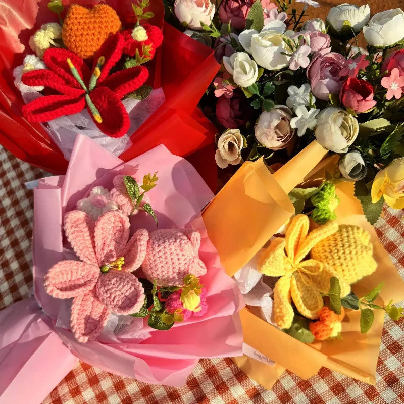 A bouquet of handmade crochet yarn flowers in various shades of pink, orange, and white, wrapped in colorful paper.