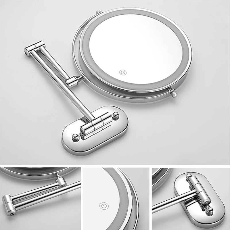 A silver illuminated double-sided magnifying makeup mirror with a handle and charging port.
