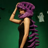 Une femme portant une peluche squelette de dinosaure violet sur un fond vert.