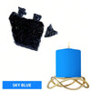 A sky blue candle in a gold wire holder next to black dye blocks.