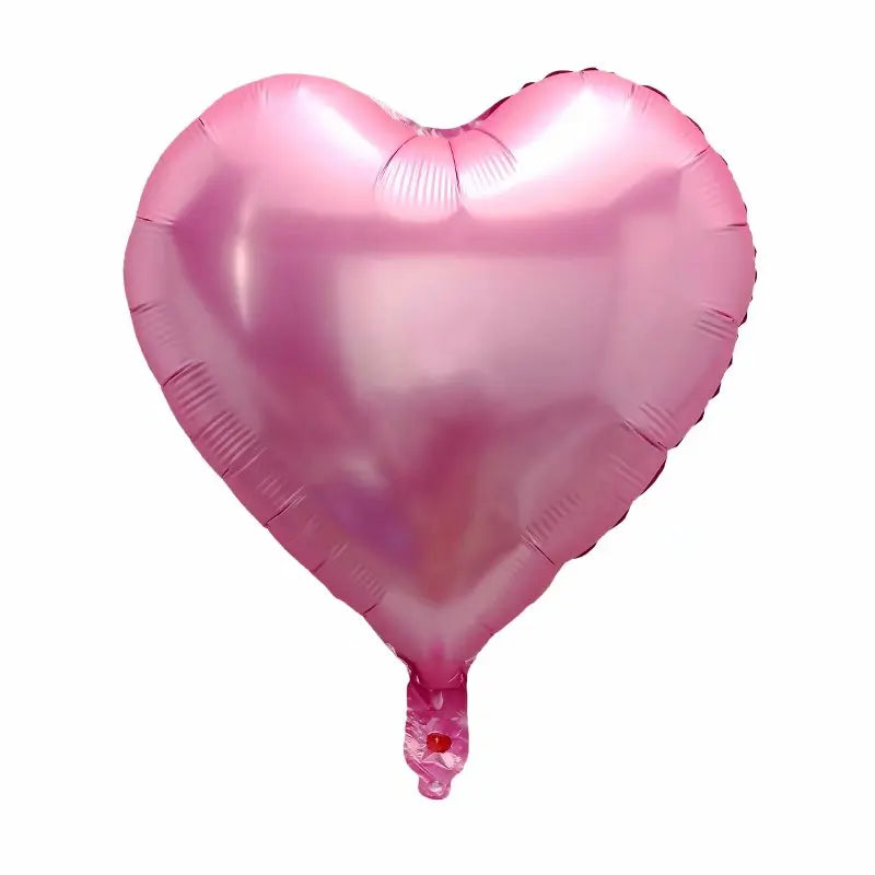 A pink heart-shaped foil balloon used for celebrations.