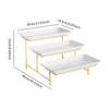 A three-tier rectangular serving platter stand with white ceramic plates and gold-colored metal legs.