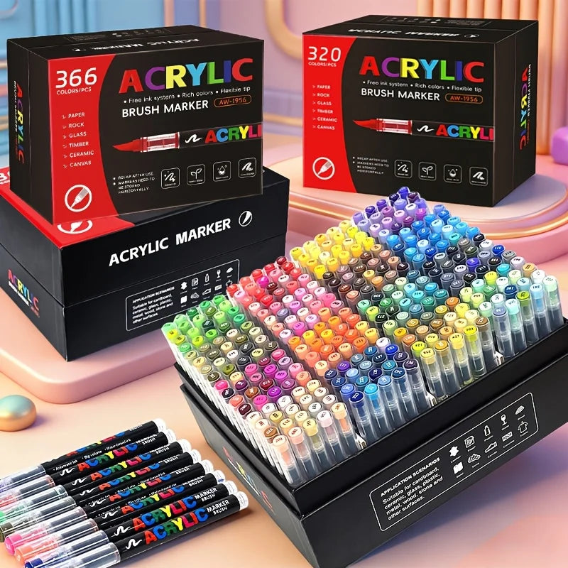 A collection of acrylic paint markers in various colors and brush tips displayed in open boxes and on a surface.