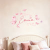 A wall sticker featuring a watercolor design of the name Emma written in pink script surrounded by pink butterflies.