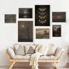 Mur de galerie avec des toiles de paysages gothiques sombres au-dessus d'un canapé clair.