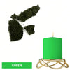 Green candle in a gold wire holder with dark green dye blocks nearby.