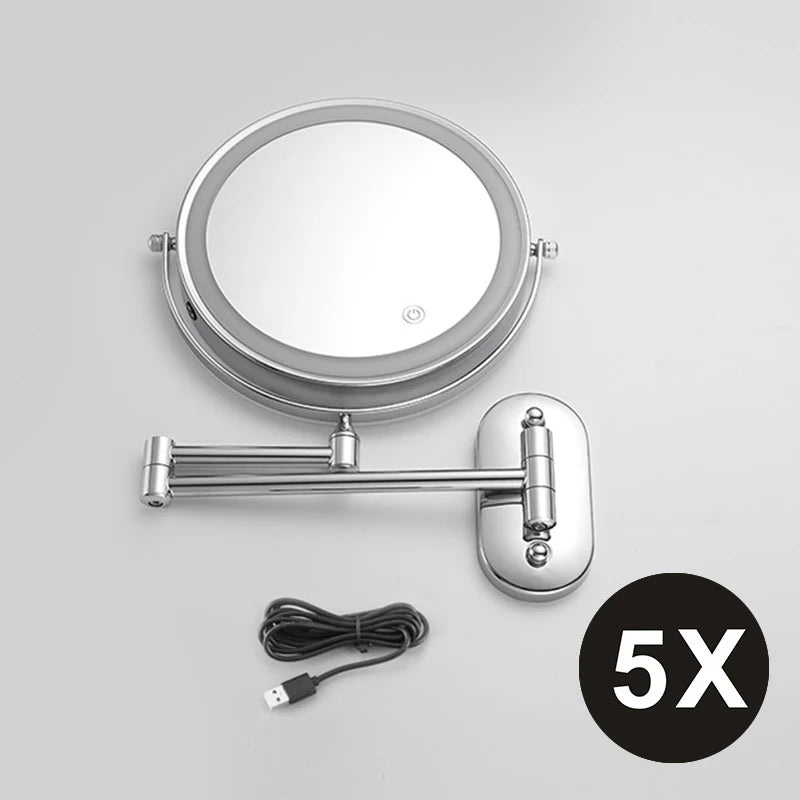 A round, silver-framed magnifying makeup mirror with a handle and USB charging cable.