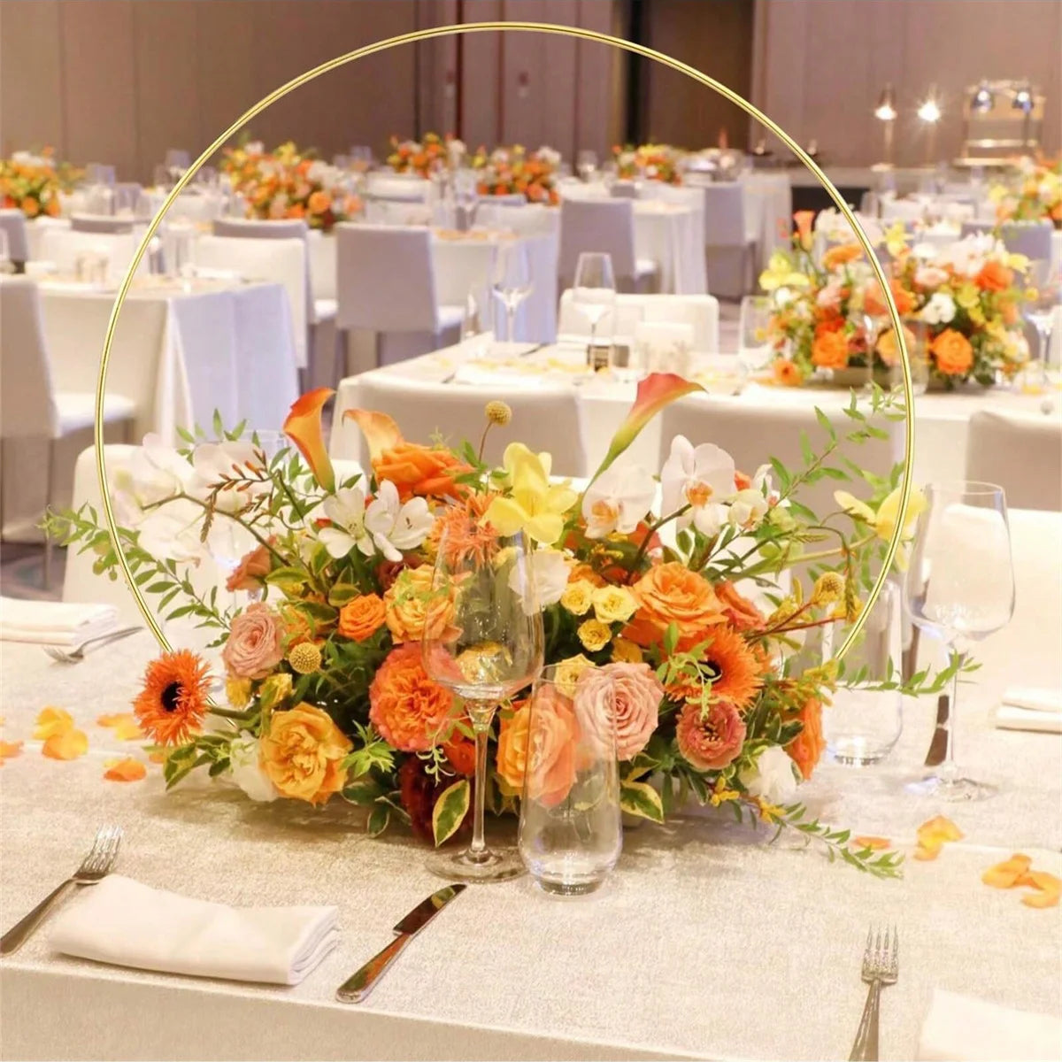 A set of ten gold metal hoop centerpieces with stands arranged on a table.