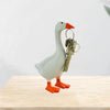 A white resin goose duck figurine with an orange beak and feet, holding a set of antique-style keys.