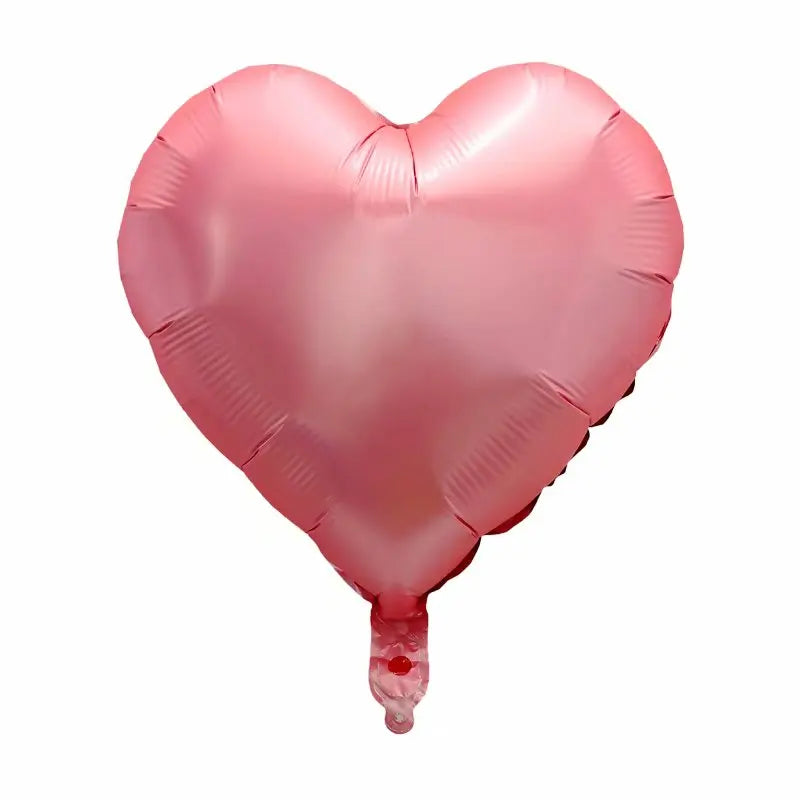 A pink heart-shaped foil balloon used for celebrations.