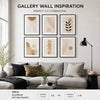 A gallery wall inspiration featuring three minimalist aluminum picture frames with neutral earth tones on a white wall.