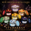 A collection of seven Evoduck chakra candles featuring real crystals and metal charms arranged on a dark wooden surface.
