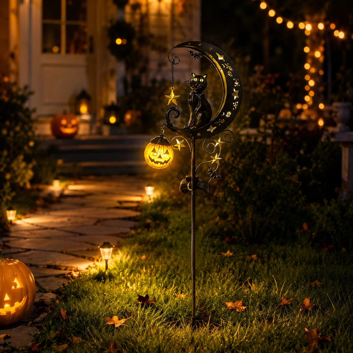 A Halloween solar garden stake light featuring a black cat moon lantern with a pumpkin glow in a dark garden setting.
