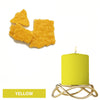 Yellow candle in a gold wire holder with yellow dye blocks nearby.