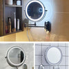 A close-up of an illuminated magnifying makeup mirror with a metal mounting bracket and USB charging connection.