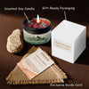 A scented soy candle in a jar with a lit wick, next to gift-ready packaging and an exclusive guide card.
