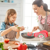 A woman and a girl are baking together using a festive Christmas silicone spatula with a wooden handle.