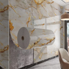 Roll of marble pattern self-adhesive wallpaper featuring gold veining on a wall