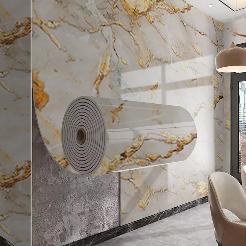 Roll of marble pattern self-adhesive wallpaper featuring gold veining on a wall